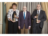 Katalin Kariko and Drew Weissman hold gold Lasker Award trophies.